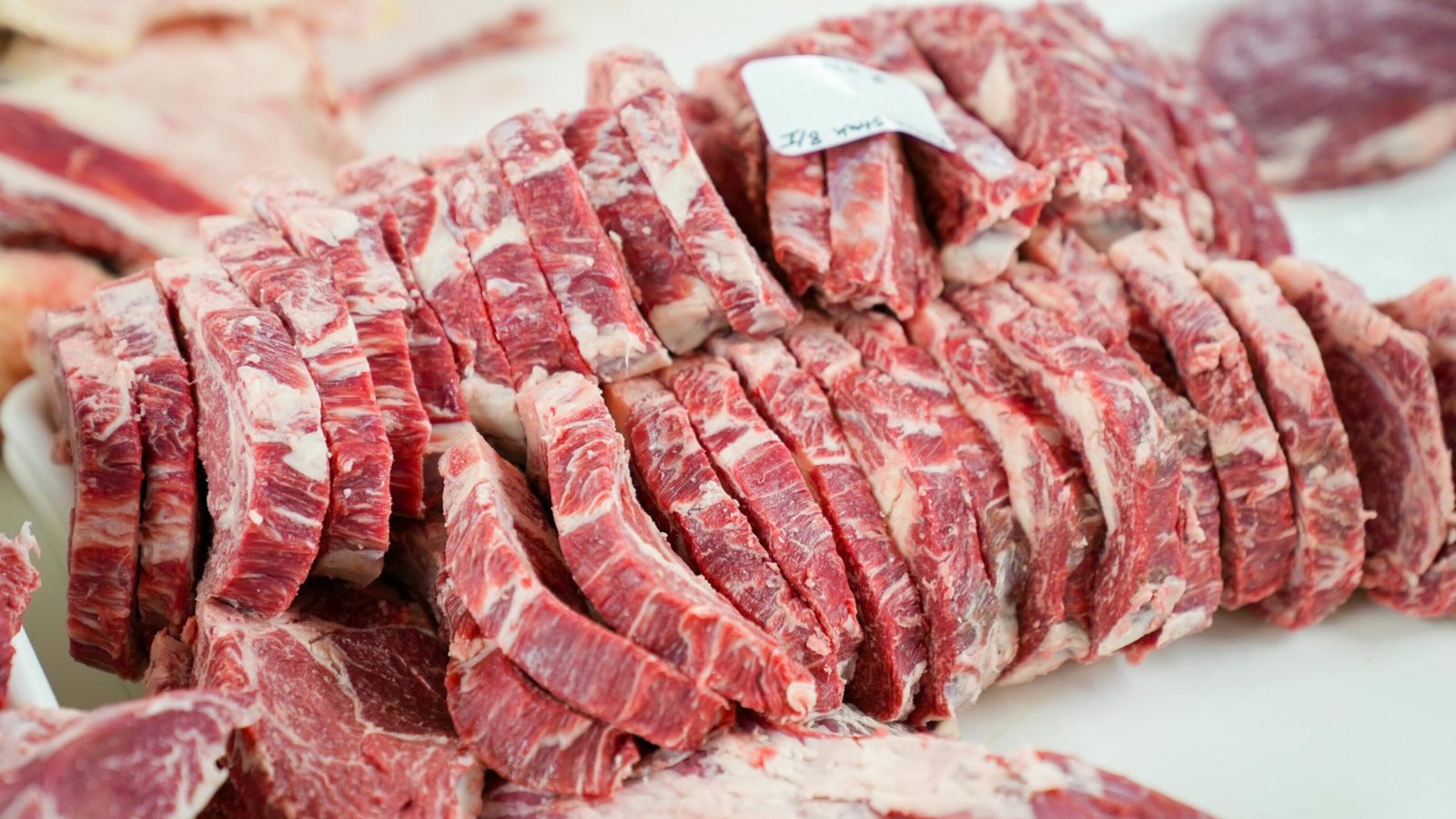 A close-up shot of sliced beef in a meat processing setting, showcasing freshness and detail.